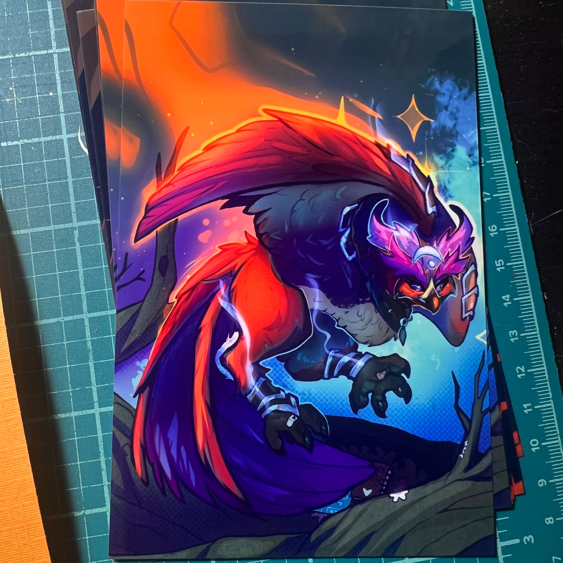 Colorful bird illustration on a card with a ruler for scale.